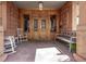Inviting porch with comfortable seating, stone columns, and a charming entry door at 1034 N Logan St # 2W, Denver, CO 80203