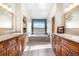 Bright bathroom with dual vanities, a soaking tub with large window and stylish fixtures at 5090 Golden Valley Trl, Castle Rock, CO 80109