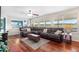 Bright living room with a large leather sofa, hardwood floors, and big windows providing scenic views at 5090 Golden Valley Trl, Castle Rock, CO 80109