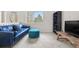 Comfortable loft area with blue sofa, tufted ottoman, and bright natural light at 5090 Golden Valley Trl, Castle Rock, CO 80109