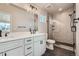 Modern bathroom features double vanity, glass enclosed shower with black fixtures and gray tile at 2187 S Fox St, Denver, CO 80223