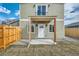 Inviting front entrance with covered porch and light green siding, creating a warm welcome at 2187 S Fox St, Denver, CO 80223