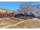 Fenced backyard with wood deck, grass, and garden beds at 11069 York St, Northglenn, CO 80233