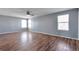 Bright bedroom with light gray walls, three windows, and hardwood floors at 11069 York St, Northglenn, CO 80233
