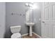 This half bathroom features a pedestal sink and a toilet, with light gray walls at 11069 York St, Northglenn, CO 80233