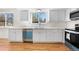 Bright kitchen featuring white cabinets, stainless steel appliances, and hardwood floors at 5556 S Sedalia St, Centennial, CO 80015