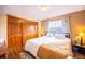 Cozy bedroom featuring a large window for natural light and closet with wood sliding doors at 830 S Vance St # F, Lakewood, CO 80226