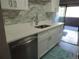 Modern kitchen with white cabinets, stainless steel appliances, marble backsplash and access to the outside deck at 9887 E Peakview Ave # F06, Englewood, CO 80111