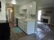 Updated kitchen with stainless steel dishwasher, white cabinets, marble backsplash and view to living area at 9887 E Peakview Ave # F06, Englewood, CO 80111