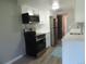 Renovated kitchen featuring a stainless steel refrigerator, range, microwave and white cabinets at 9887 E Peakview Ave # F06, Englewood, CO 80111