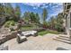 Beautiful backyard featuring a stone patio with outdoor seating, a grassy area, and lush landscaping at 10935 Valleybrook Cir, Highlands Ranch, CO 80130