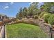 Multi-tiered backyard with retaining walls, landscaping, a grassy area, and wrought iron fencing at 10935 Valleybrook Cir, Highlands Ranch, CO 80130