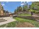 Multi-tiered backyard with retaining walls, landscaping, a grassy area, stone patio and wrought iron fencing at 10935 Valleybrook Cir, Highlands Ranch, CO 80130
