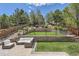 Beautiful backyard featuring a stone patio with outdoor seating, a grassy area, and lush landscaping at 10935 Valleybrook Cir, Highlands Ranch, CO 80130