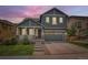Charming two-story home boasts a well-maintained lawn and a welcoming front porch with stone accents at 10935 Valleybrook Cir, Highlands Ranch, CO 80130