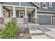 Inviting front porch featuring stone pillars and a gray front door, enhanced by manicured landscaping at 10935 Valleybrook Cir, Highlands Ranch, CO 80130