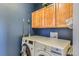 This laundry room features front load washer/dryer and upper cabinets at 10935 Valleybrook Cir, Highlands Ranch, CO 80130