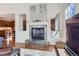 Cozy living room with a fireplace, hardwood floors, and a view into the kitchen at 10935 Valleybrook Cir, Highlands Ranch, CO 80130