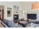 Cozy living room with a stone fireplace, hardwood floors, and a view into the adjoining kitchen at 10935 Valleybrook Cir, Highlands Ranch, CO 80130