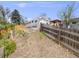 View of backyard space surrounded by wooden fencing, lush vegetation and mature landscaping on an uphill slope at 6863 S Detroit Cir, Centennial, CO 80122