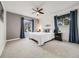 Cozy bedroom with a ceiling fan and large windows draped with decorative curtains at 6863 S Detroit Cir, Centennial, CO 80122
