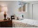 Comfortable bedroom with a window and a decorative nightstand and lamp at 6863 S Detroit Cir, Centennial, CO 80122
