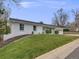Well-maintained white brick home with a green lawn and manicured landscaping, enhancing its curb appeal at 6863 S Detroit Cir, Centennial, CO 80122