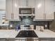 Close up view of a modern kitchen with a stainless steel range and dark backsplash at 6863 S Detroit Cir, Centennial, CO 80122