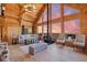 Vaulted living room featuring wood-paneled walls, fireplace, and expansive windows with stunning outdoor views at 10268 Christopher Dr, Conifer, CO 80433