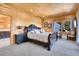 Cozy bedroom with wood-paneled walls, a comfortable bed, and exterior view at 10268 Christopher Dr, Conifer, CO 80433