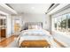 Bright main bedroom featuring a padded headboard, bench, and access to a balcony at 3380 Longwood Ave, Boulder, CO 80305