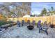 Paver patio with a fire pit and Adirondack chairs surrounded by a wooden fence and mature trees at 6431 W Arbor Ave, Littleton, CO 80123