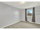 This bedroom features neutral walls, gray carpet, a bright window, and a shelving unit at 6431 W Arbor Ave, Littleton, CO 80123