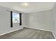 This bedroom features neutral walls, gray carpet, a bright window, and a shelving unit at 6431 W Arbor Ave, Littleton, CO 80123