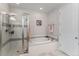 Bright bathroom featuring a glass enclosed shower and a soaking tub, with white tile at 5736 Cadara Way, Parker, CO 80134