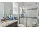 Bathroom featuring a glass shower with a built in seat, granite counter, and window at 5736 Cadara Way, Parker, CO 80134