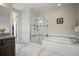 Bright bathroom with a walk-in shower, soaking tub, and granite countertop vanity at 5736 Cadara Way, Parker, CO 80134