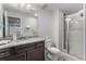 Bright bathroom with a granite vanity, shower with glass door and tile surround at 5736 Cadara Way, Parker, CO 80134