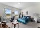 Comfortable bedroom with a large bed, sitting area, dresser, and a view of the outside landscape at 5736 Cadara Way, Parker, CO 80134