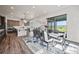 Bright dining area features a modern table, large windows, and an adjacent open-concept kitchen at 5736 Cadara Way, Parker, CO 80134