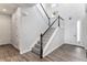 Well-lit entryway with hardwood floors, staircase with dark wood railing, and white accents at 5736 Cadara Way, Parker, CO 80134