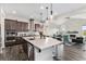 Bright kitchen featuring a spacious island with bar seating, modern appliances, pendant lights, and decorative backsplash at 5736 Cadara Way, Parker, CO 80134
