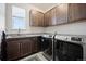 Convenient laundry room features modern washer, dryer, stylish cabinets and granite countertops for efficient chores at 5736 Cadara Way, Parker, CO 80134