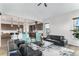 Open-concept living room with modern decor, comfortable seating, and a view of the kitchen and dining area at 5736 Cadara Way, Parker, CO 80134