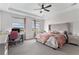 Spacious main bedroom with a tufted headboard, neutral tones, and scenic views from large windows at 5736 Cadara Way, Parker, CO 80134