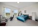 Spacious main bedroom boasts two windows with green views, chair, and stylish blue bedding at 5736 Cadara Way, Parker, CO 80134
