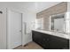 Modern bathroom featuring double sinks, dark cabinets, and a decorative tile accent wall at 4062 W 16Th Ave, Denver, CO 80204