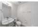 Bright bathroom with a sleek pedestal sink, modern fixtures, and neutral tile flooring at 4062 W 16Th Ave, Denver, CO 80204