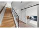 Inviting entryway featuring wood stairs, modern railing, and a sliding barn door to the living room at 4062 W 16Th Ave, Denver, CO 80204