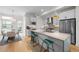 Modern kitchen with stainless steel appliances, island with seating, and dining area with a glass table at 4062 W 16Th Ave, Denver, CO 80204